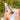 woman holding rubber ducky mineral sunscreen for face while sitting outside on the grass